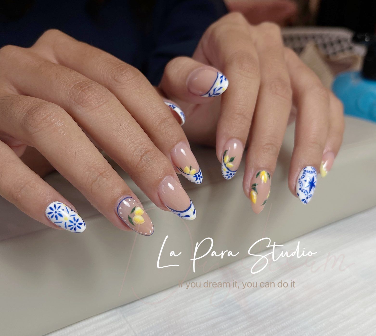 Blue and yellow floral nail art on almond nails
