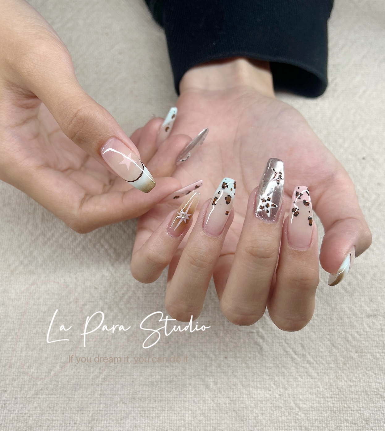 Glossy nude nail design with metallic and leopard print accents